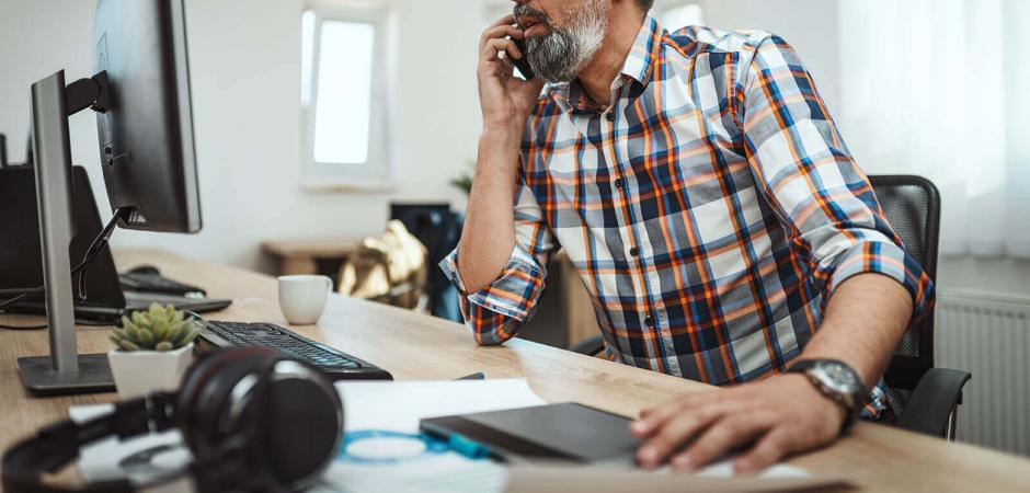 man on computer and phone